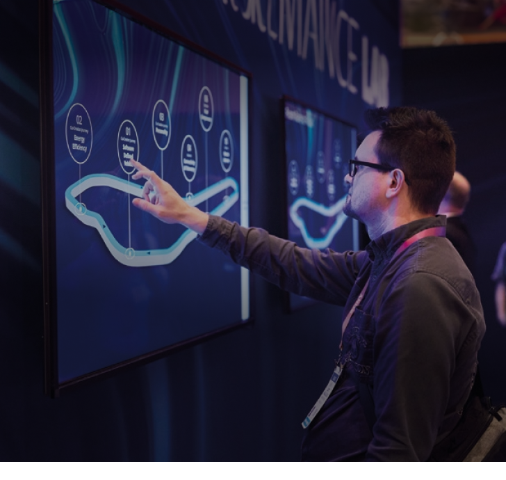 Man interacting with a touch screen with a race circuit on it at a convention