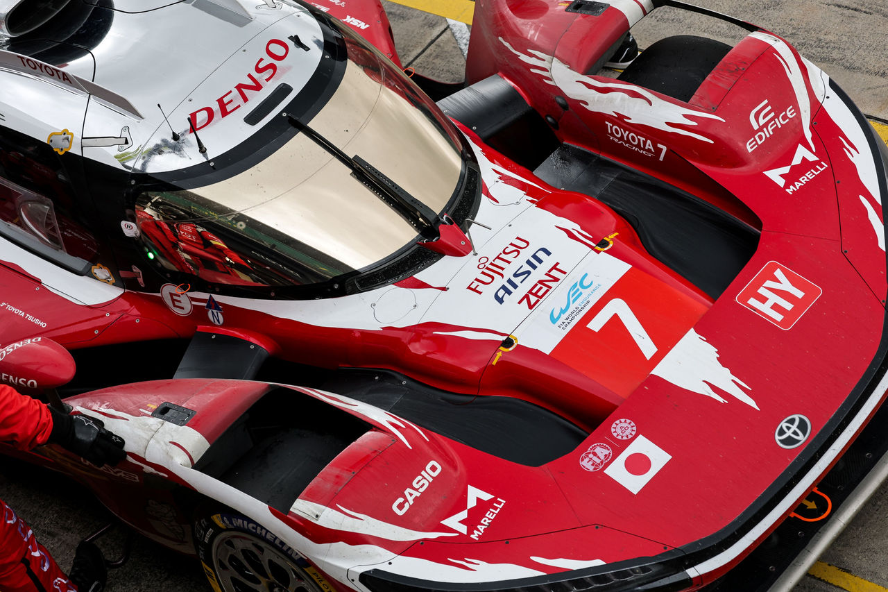 Top-down view of a red-and-white Toyota endurance race car in the pit lane, showing the cockpit canopy, aerodynamic bodywork, and the number 7 with multiple sponsor logos.