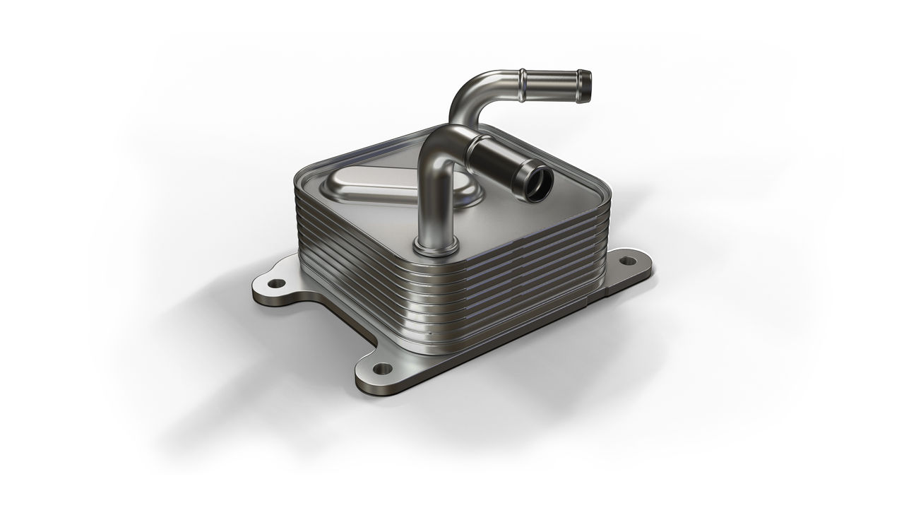 Compact metal oil cooler with stacked plates and two curved pipe connections.